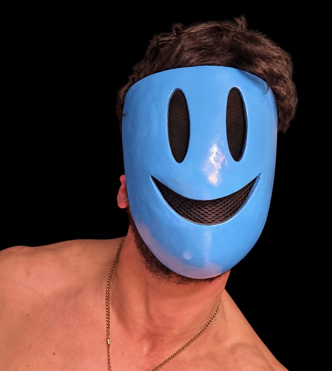 Blue SMILE mask being worn against a black background